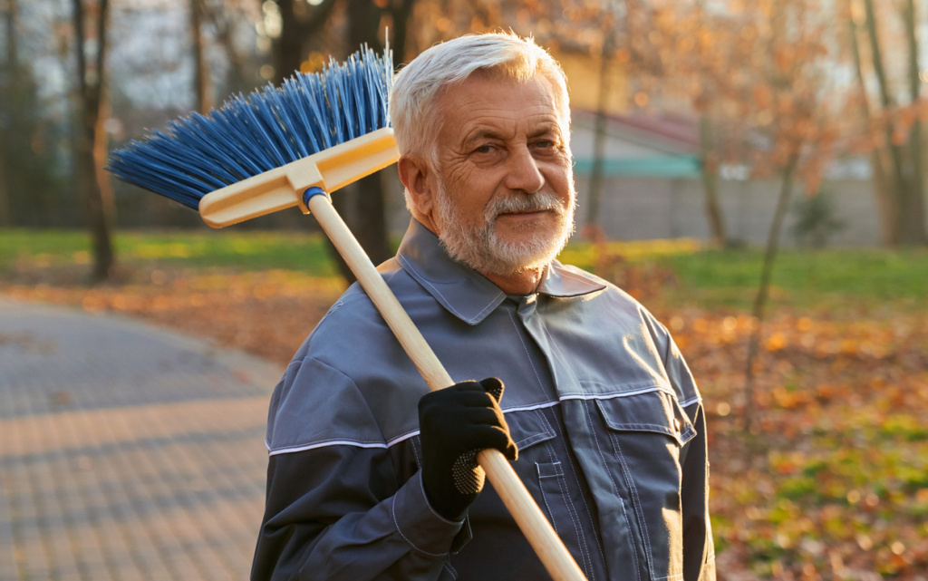 smiling-maintenance-male-worker-looking-camera-while-keeping-broom-shoulder-portrait (1) (1).jpg