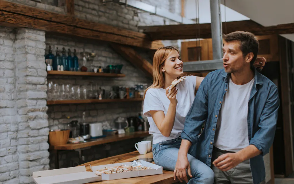 smiling-couple-enjoying-pizza-at-home-together-2026-09-21-21-24-26-utc (1).jpg