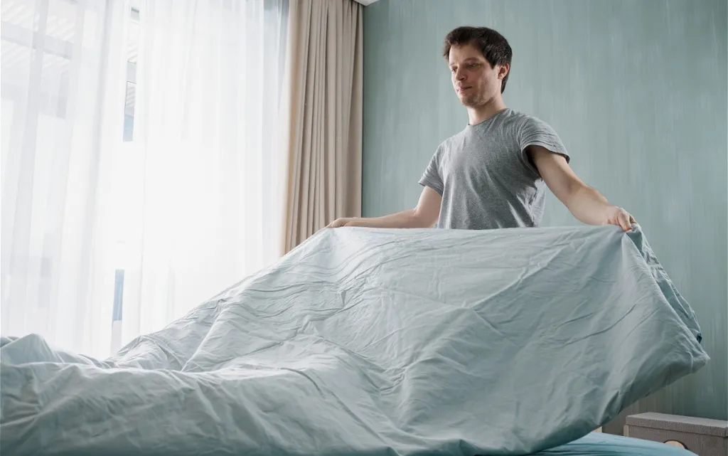 man-making-bed-in-the-morning-light-2026-09-23-06-21-01-utc (1).jpg