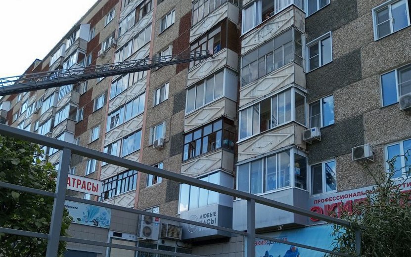 Сидящий на окне многоэтажки ребенок напугал жителей Ижевска