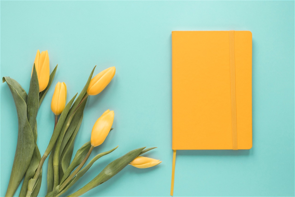 yellow-tulip-flowers-with-notebook-table.jpg