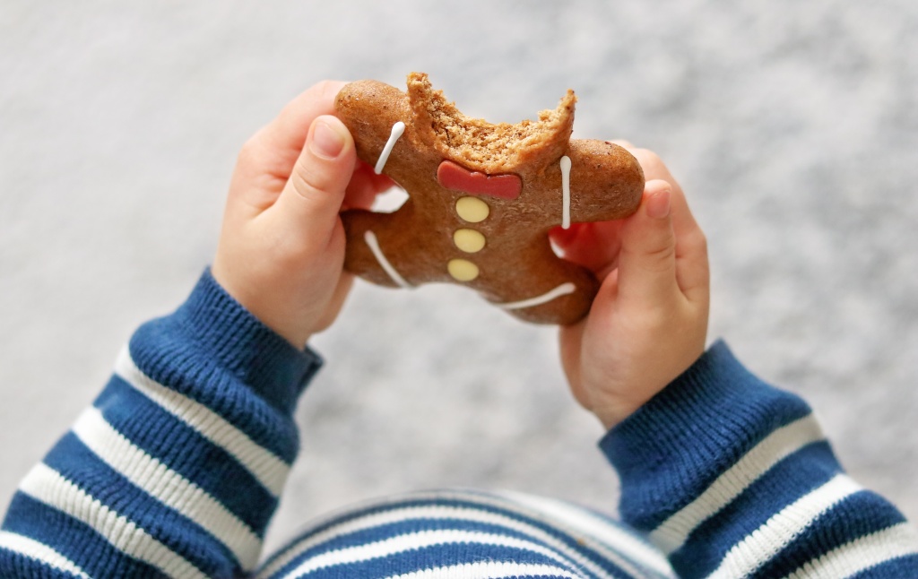 little-child-eating-christmas-gingerbread-man-bisc-2022-11-15-18-05-06-utc.jpg
