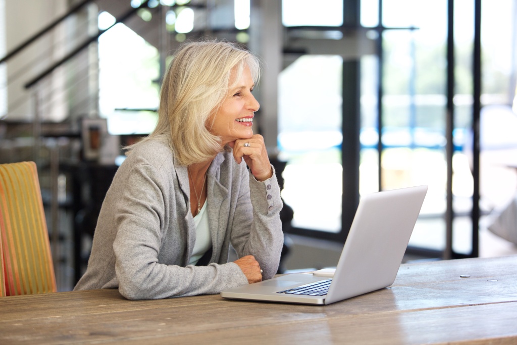 smiling-older-woman-working-laptop-computer-indoor-2023-11-27-05-30-14-utc.jpg