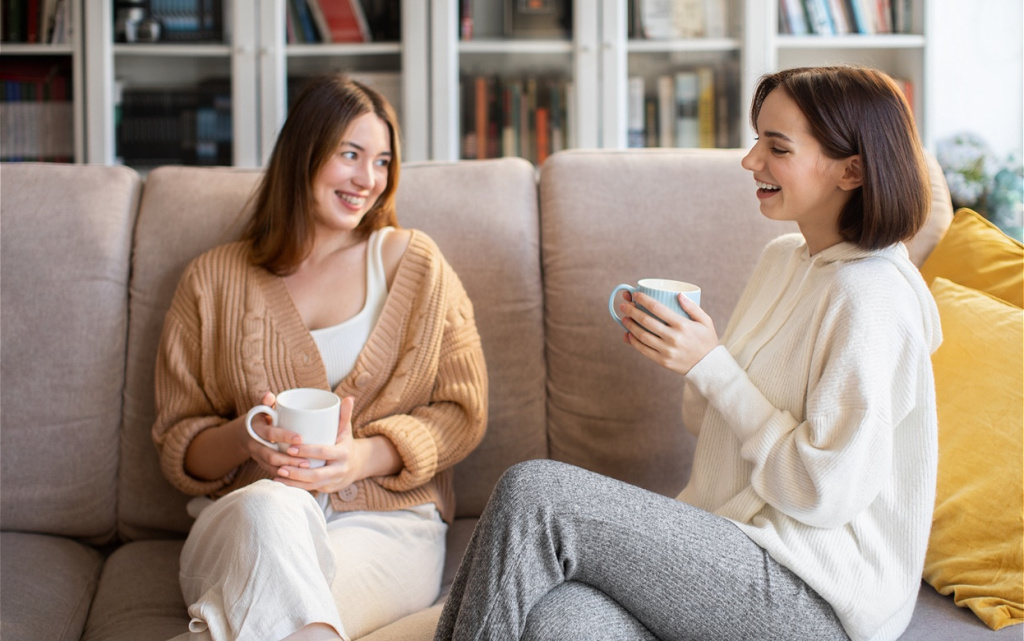 two-smiling-young-women-relaxing-on-sofa-2026-01-09-06-56-43-utc (1).jpg