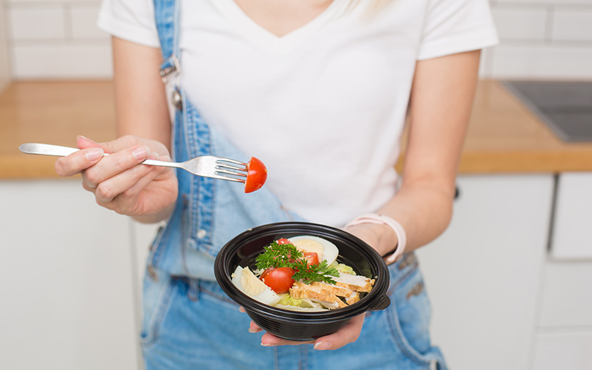 young-woman-holding-a-plate-with-salad-delivery-2022-11-15-04-15-04-utc.jpg