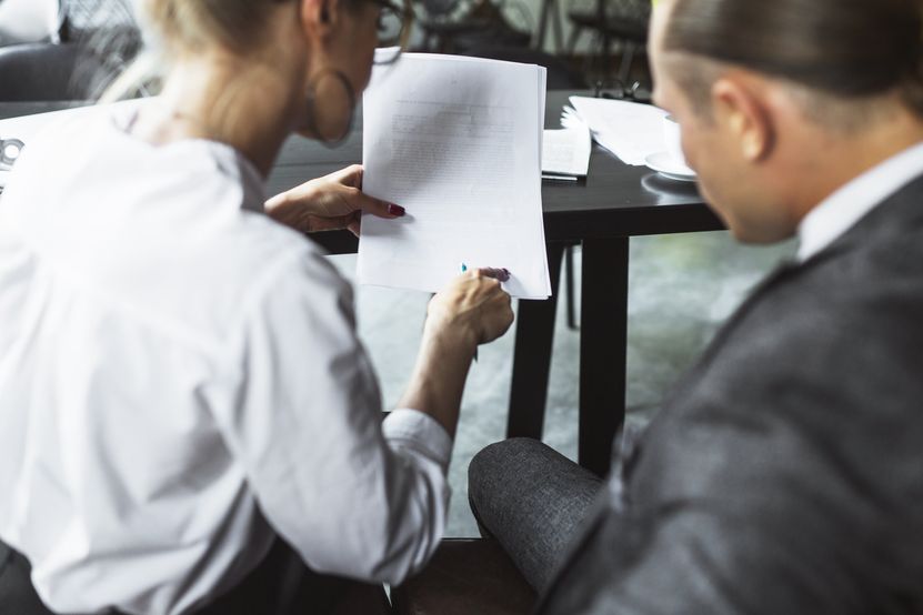 rear-view-two-businesspeople-examining-document-caf.jpg