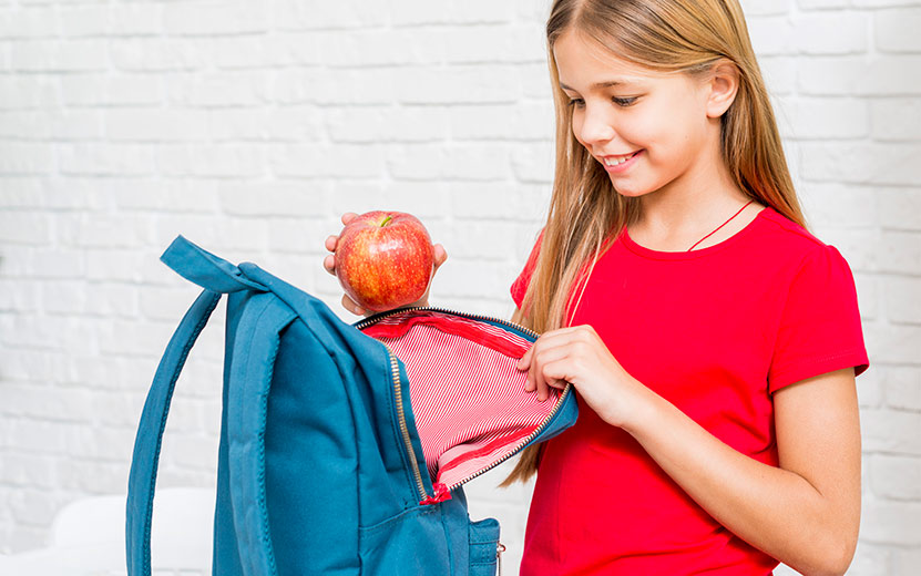 happy-girl-putting-apple-backpack.jpg