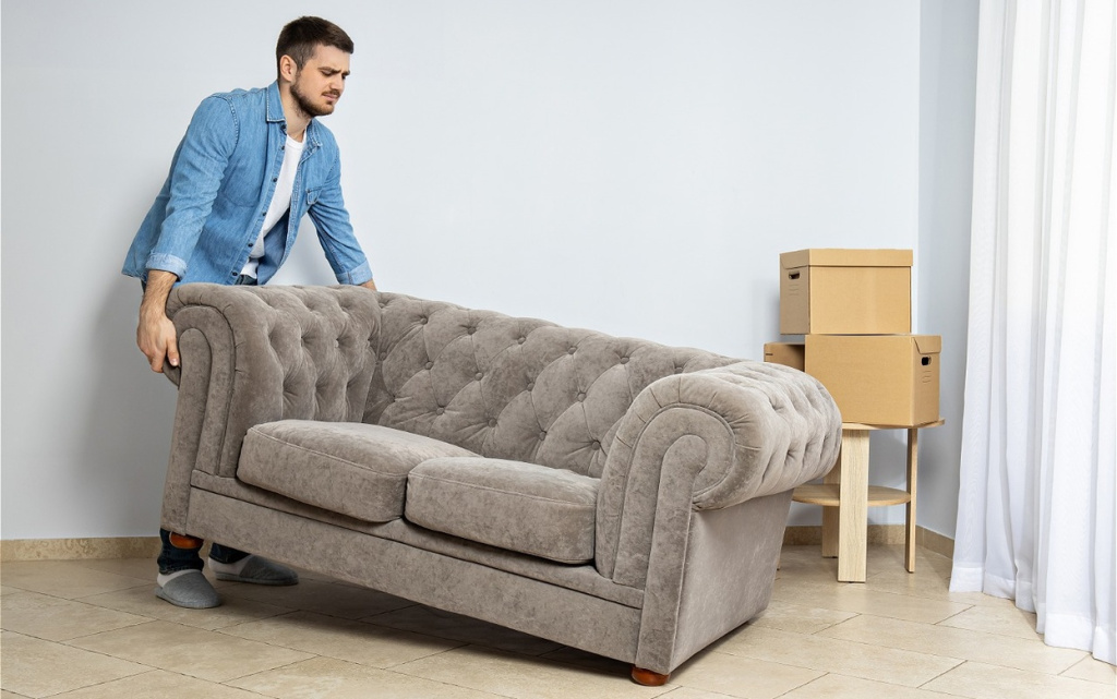 man-moves-tufted-sofa-in-bright-room-2026-03-24-23-27-06-utc (1).jpg