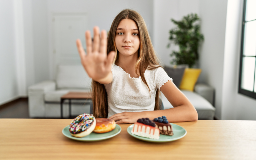 young-brunette-teenager-eating-cakes-sweets-with-open-hand-doing-stop-sign-with-serious-confident-expression-defense-gesture (1).jpg