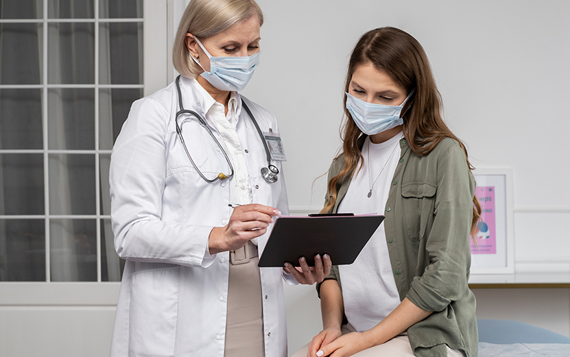 medium-shot-doctor-patient-wearing-masks.jpg