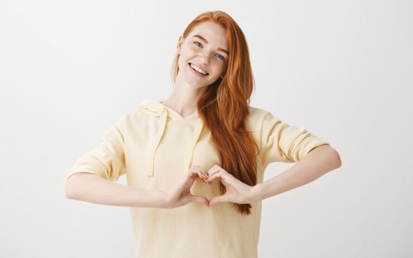 lovely-redead-woman-showing-heart-gesture-smiling_176420-21240.jpg