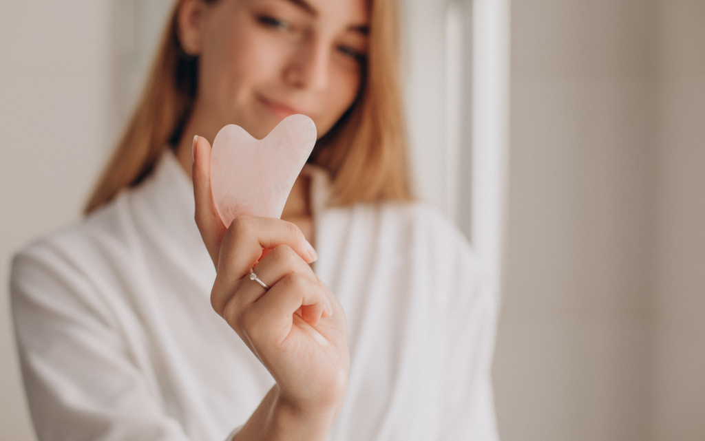 woman-doing-self-massage-with-rose-quartz-gua-sha-stone (1) (1).jpg