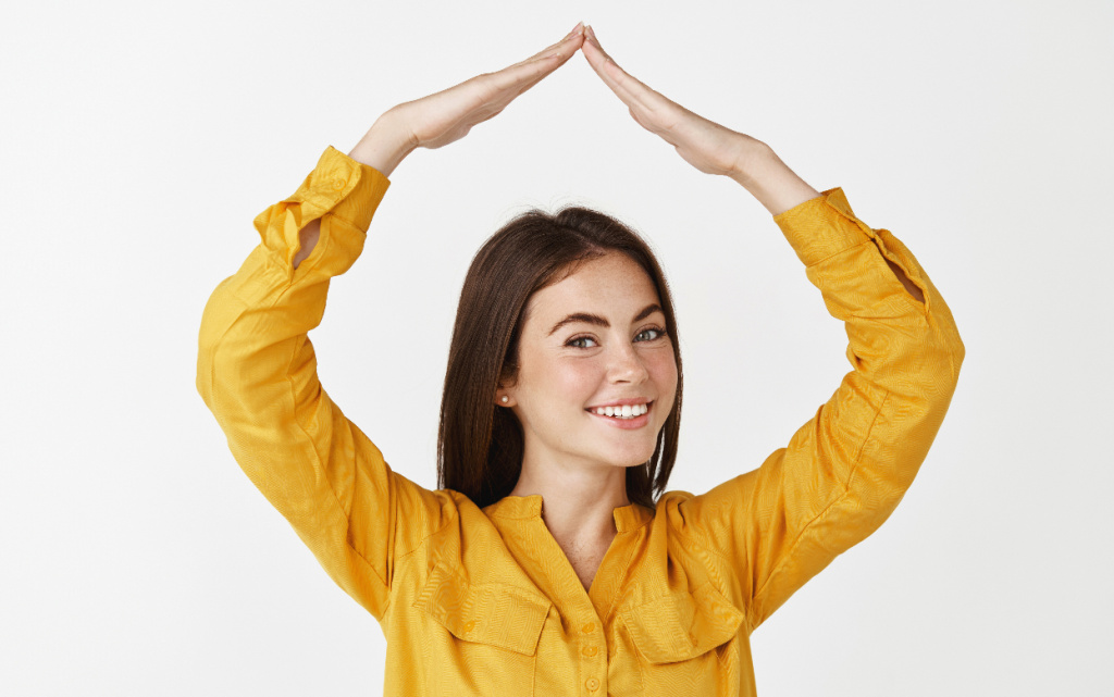 beautiful-adult-woman-making-house-roof-with-hands-head-smiling-looking-happy-standing-white-wall (1) (1).jpg