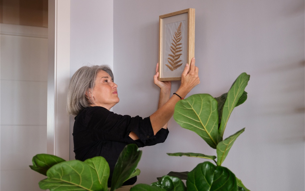 woman-hanging-framed-fern-print-on-wall-indoors-2026-09-22-11-57-55-utc (1).jpg