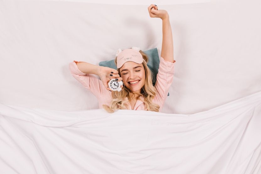 cheerful-woman-stretching-bed.jpg