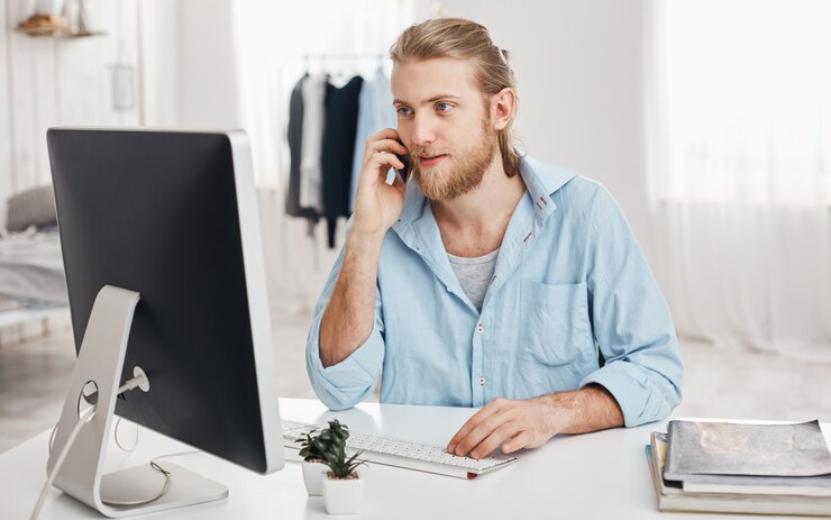 bearded-skilled-young-fair-haired-businessman-works-new-project-sits-front-screen-has-phone-conversation-discusses-financial-report-with-businesspartner-office-worker-chats-with-boss_176420-14537.jpg