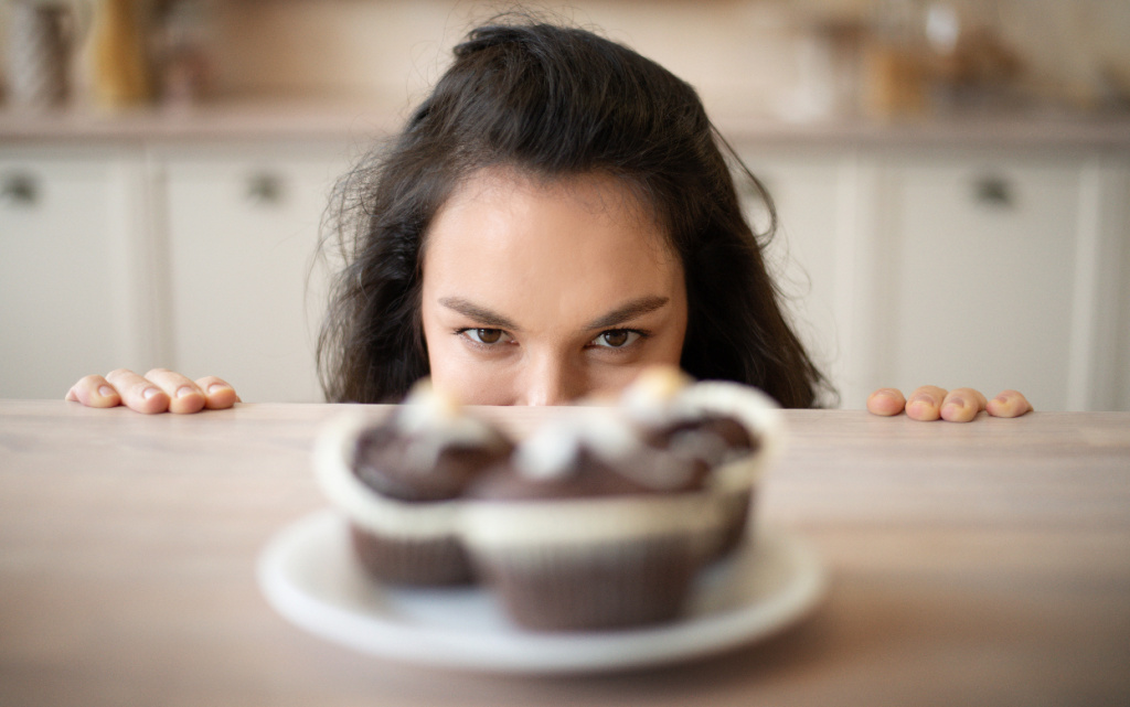 woman-peeking-over-table-at-cupcakes-indoors-2026-01-08-23-23-37-utc (1).jpg