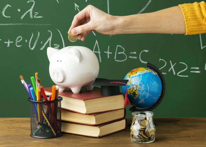 person-putting-coins-piggy-bank-with-books-pencils.jpg