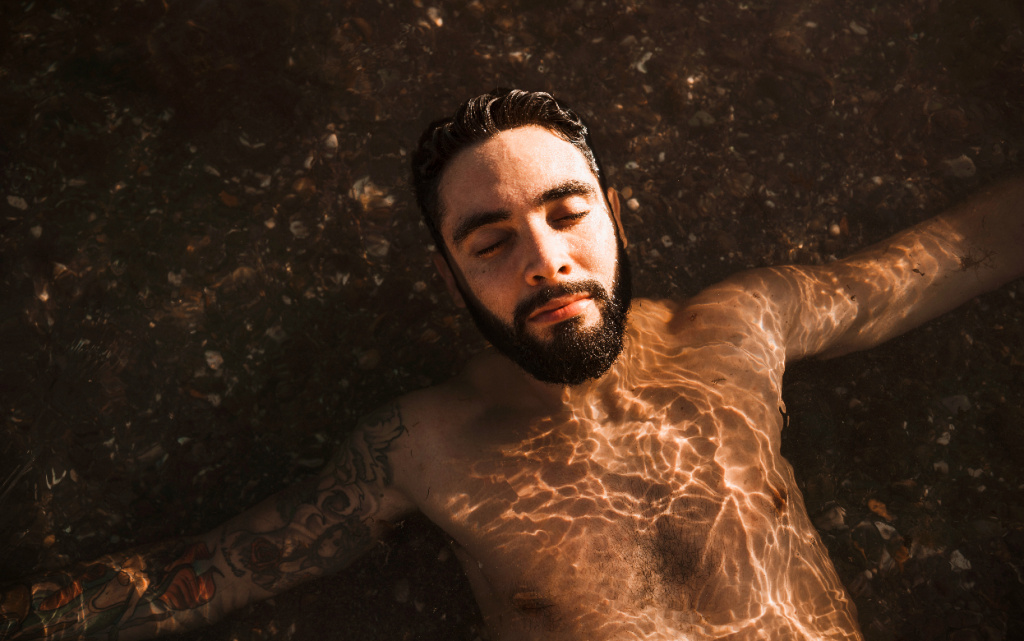 molodoi-borodatyi-paren-lezal-na-vode-na-beregu (1).jpg