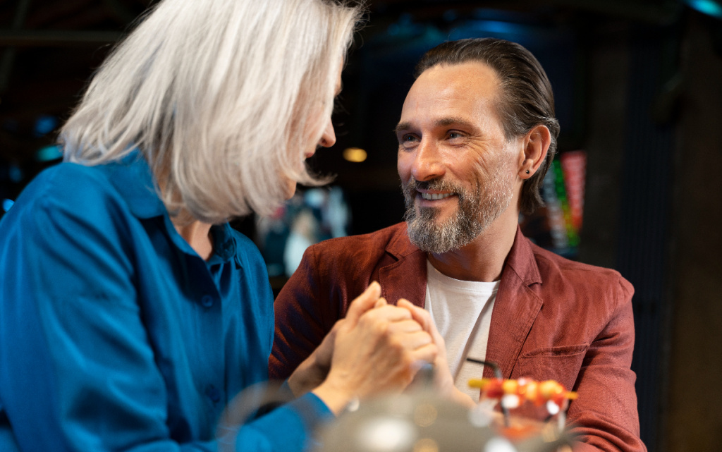 senior-man-surprising-his-friend-holding-her-hands-restaurant (1).jpg