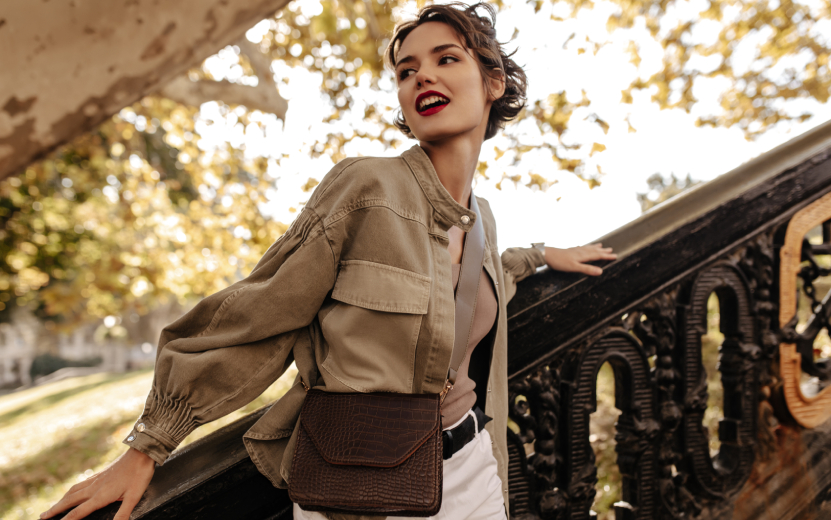 modern-woman-denim-jacket-white-pants-looking-away-outside-wavy-haired-woman-with-red-lips-with-handbag-posing-near-stairs (1).jpg