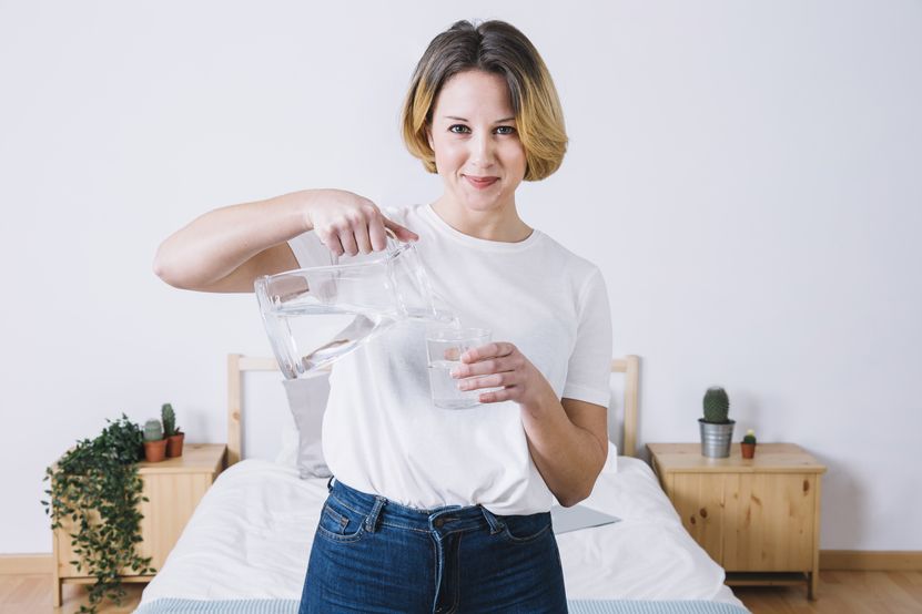 woman-pouring-water-looking-camera.jpg