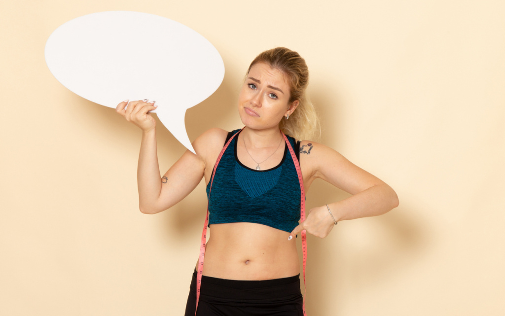 front-view-young-female-sport-outfit-holding-white-sign-measuring-her-body (1) (1).jpg