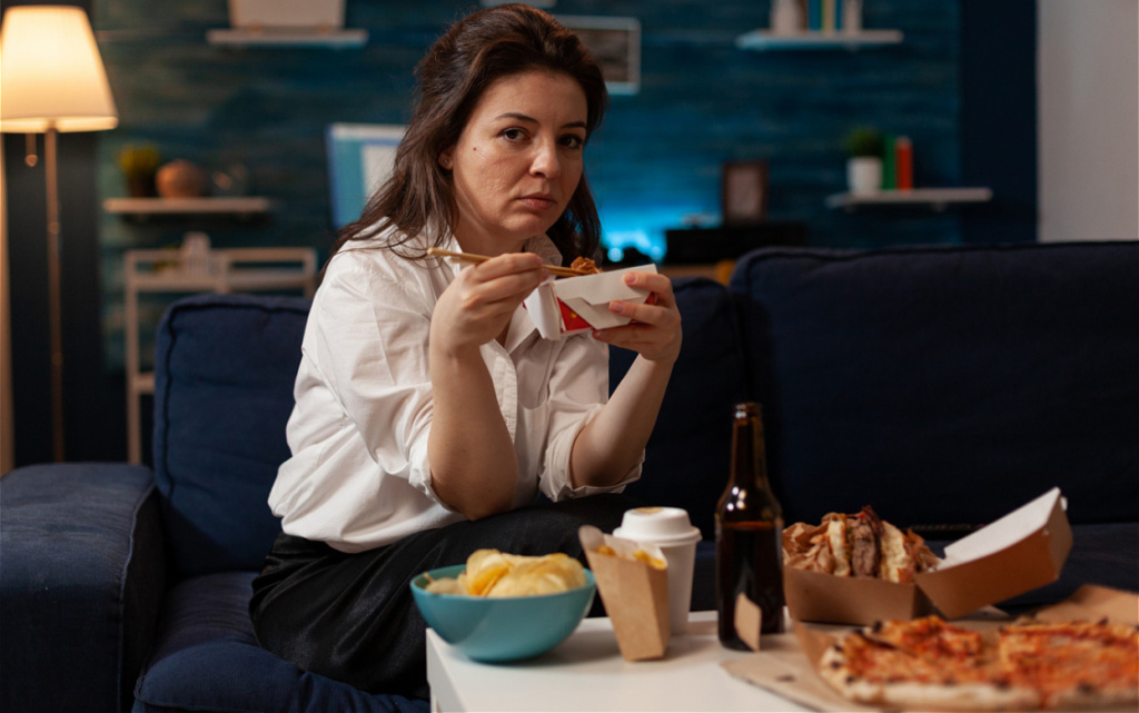 woman-eats-takeout-while-sitting-on-couch-2026-09-23-17-35-02-utc (1).jpg