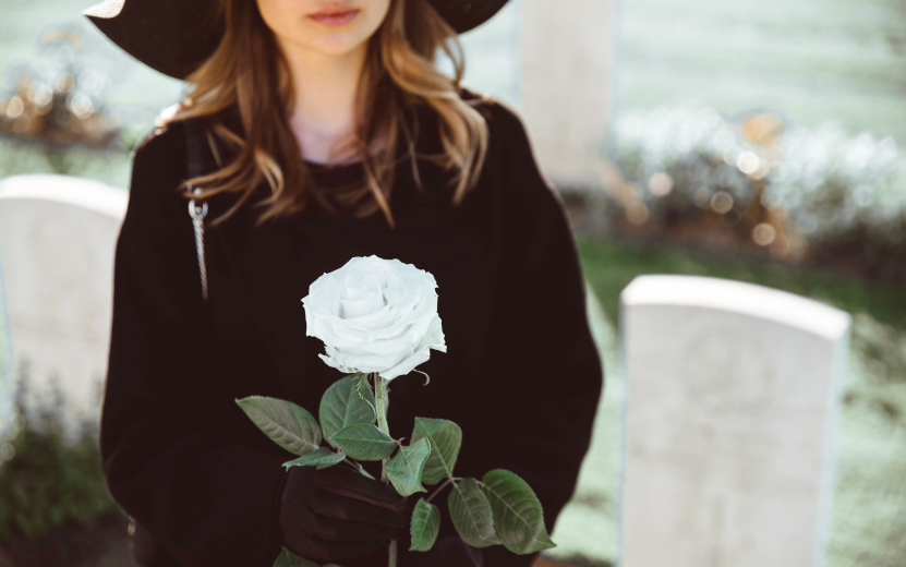 sad-woman-in-the-cemetery-holding-bouquet-of-roses-2023-11-27-05-25-45-utc.jpg
