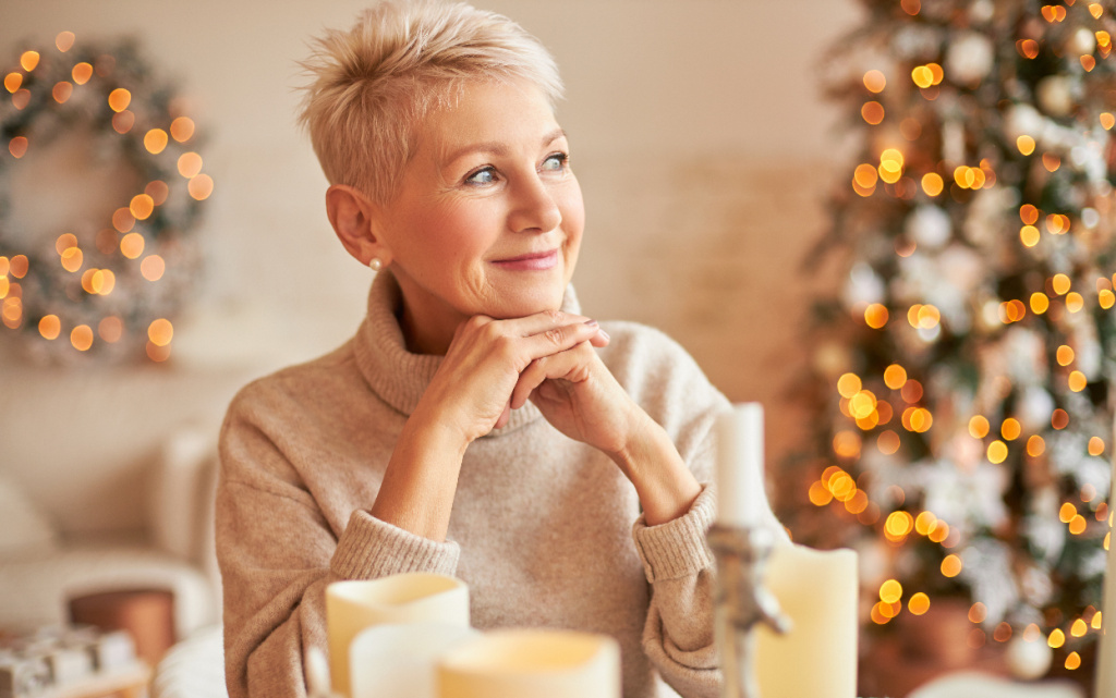 mirnaa-stil-naa-kavkazskaa-zensina-srednih-let-v-ogromnom-svitere-s-zadumcivym-mectatel-nym-vyrazeniem-lica-ulybaetsa-sidit-za-stolom-so-svecami-i-zdet-druzei-ctoby-otprazdnovat-socel-nik (1).jpg