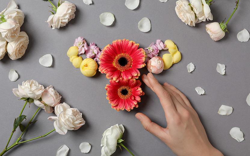 uterus-flowers-female-hand-gray-background-top-view.jpg