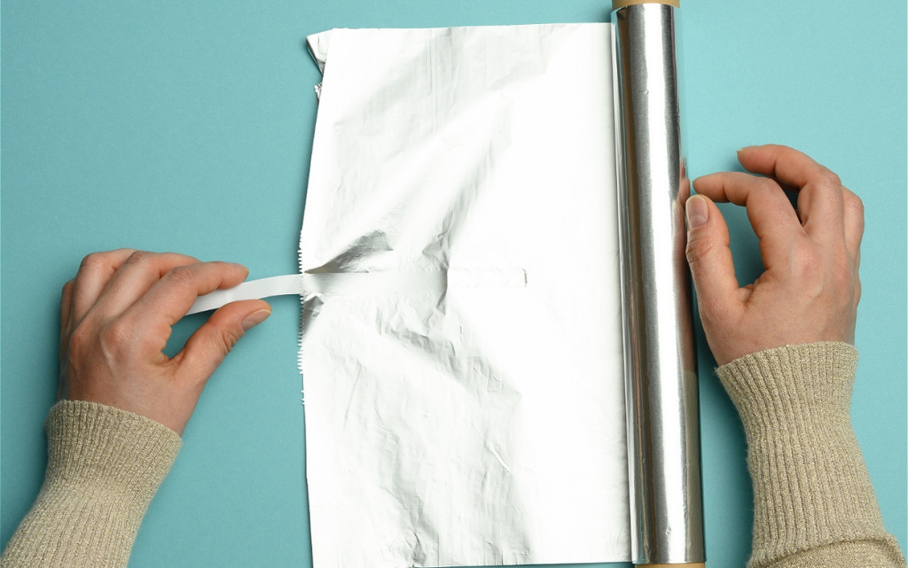 female-hand-holds-an-unfolded-roll-of-gray-foil-on-2026-03-26-04-03-10-utc (1).jpg