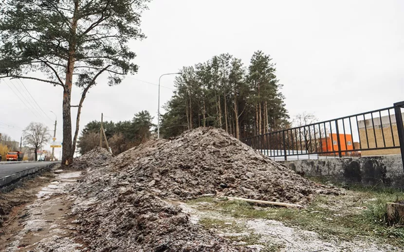 По бокам от тротуара лежат горы грязи