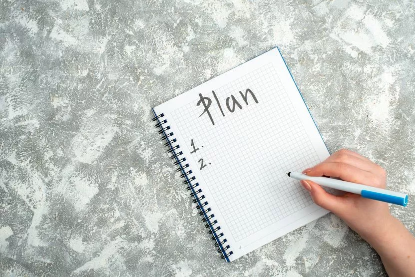 overhead-view-hand-writing-spiral-notebook-gray-background.jpg