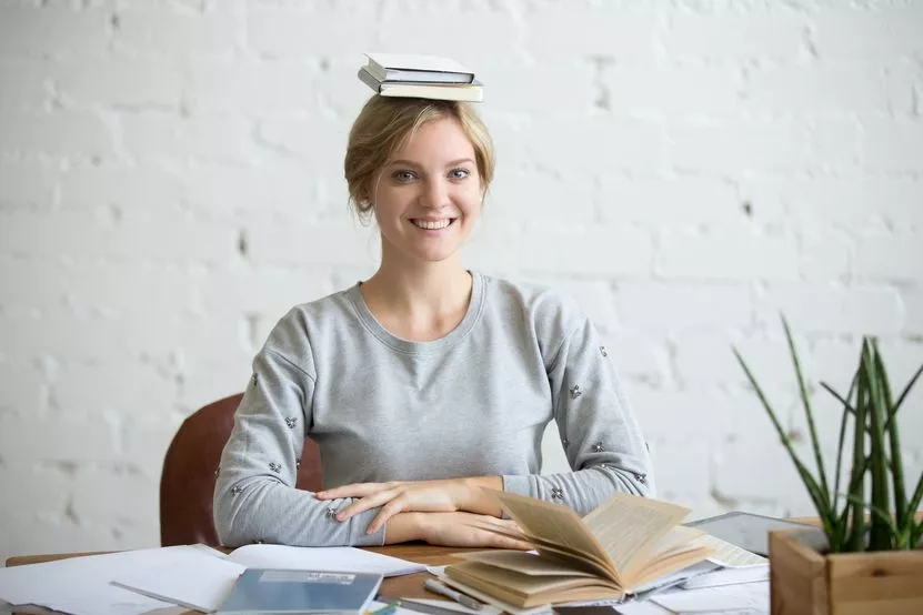 portrait-smiling-woman-desk-books-her-head.jpg