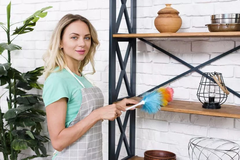 portrait-young-female-cleaner-cleaning-shelves-with-duster.jpg