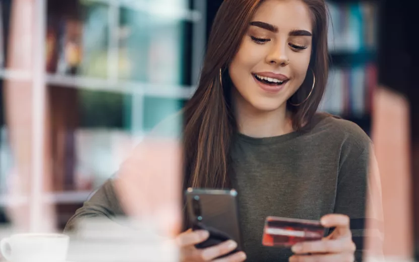 woman-using-smartphone-and-a-credit-card-for-onlin-2023-11-27-05-12-41-utc.jpg
