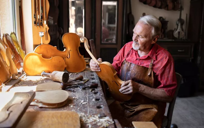 senior-carpenter-assembling-parts-violin-instrument-his-carpenter-s-workshop_342744-1411.jpg