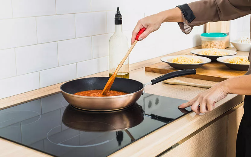 person-mixing-sauce-pan-stove.jpg