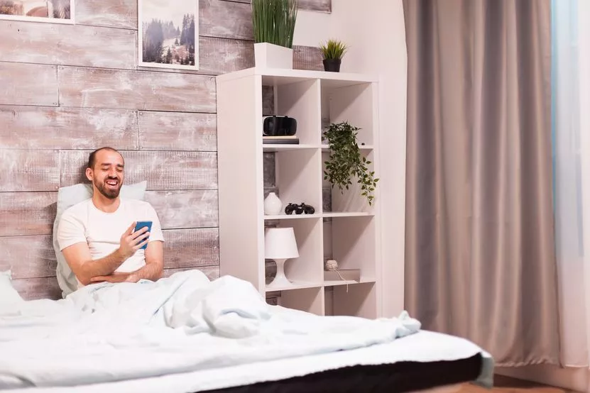 cheerful-man-pajamas-laughing-while-watching-funny-video-smartphone-night-comfortable-bed.jpg