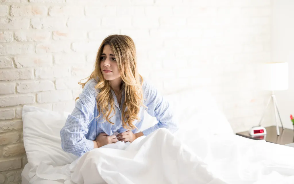 krasivaa-zensina-v-pizame-ploho-seba-cuvstvuet-i-stradaet-ot-menstrual-nyh-spazmov-v-svoei-posteli (1).jpg