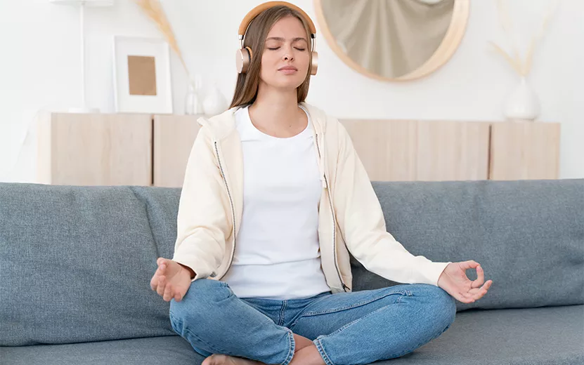 calm-young-woman-sitting-on-couch-practicing-medi-2023-11-27-05-10-41-utc.jpg