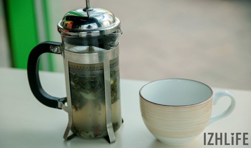 В чайник поместите зеленый чай, лимон, смесь имбиря с мёдом. Залейте смесь кипятком.